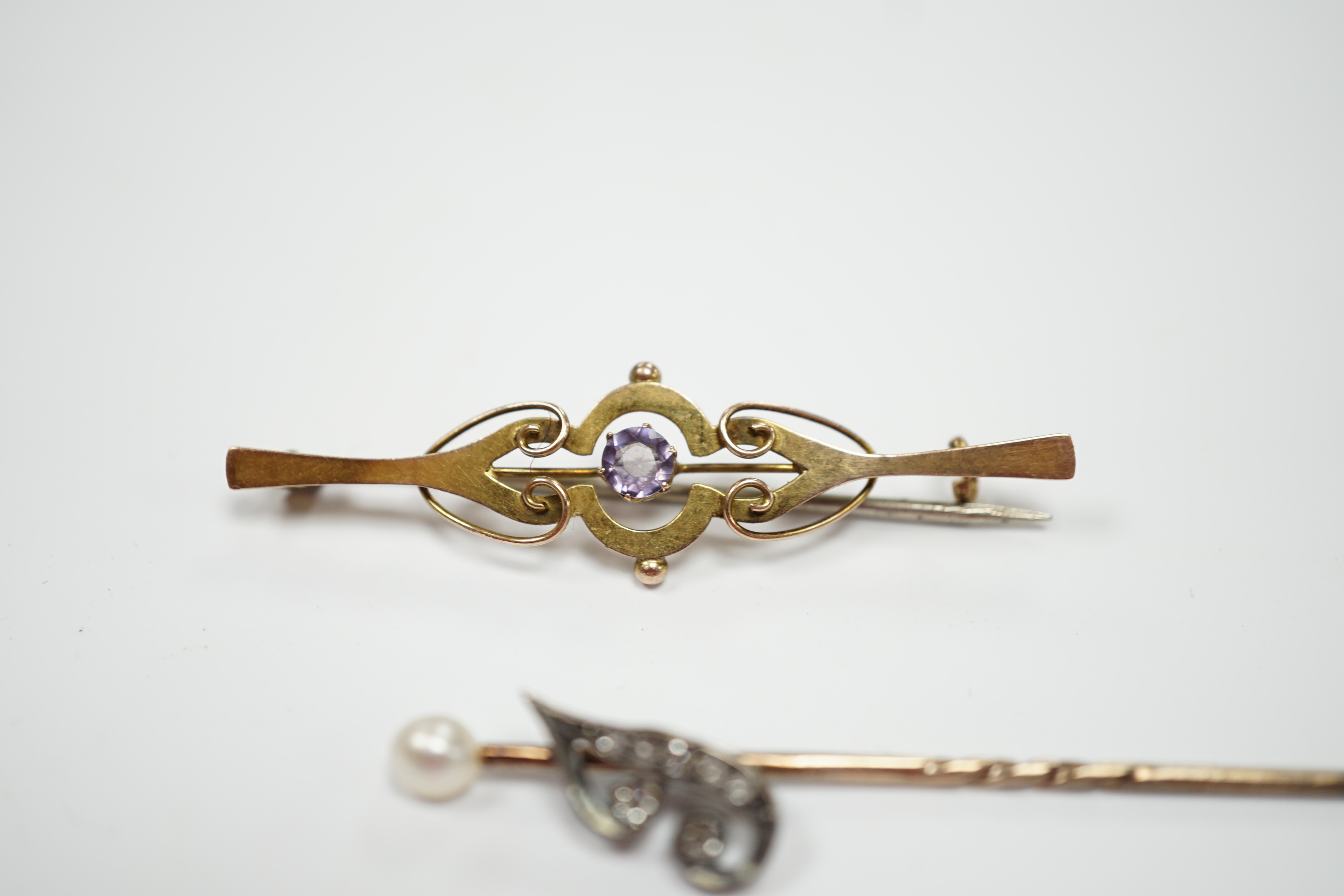 An early 20th century diamond chip and seed pearl set initial stick pin, 65mm and a 9ct and gem set brooch.
